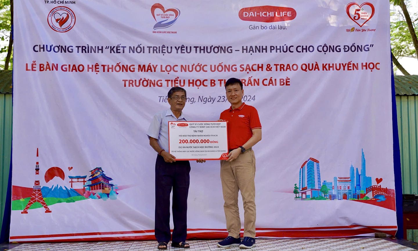 Ông Trần Đình Quân, Chủ tịch HĐTV Dai-ichi Life VN,  Chủ tịch Quỹ Vì cuộc sống tươi đẹp, trao biểu trưng tài trợ cho ông Nguyễn Văn Rảnh, Phó Chủ tịch Hội Bảo trợ Bệnh nhân nghèo TP.HCM.