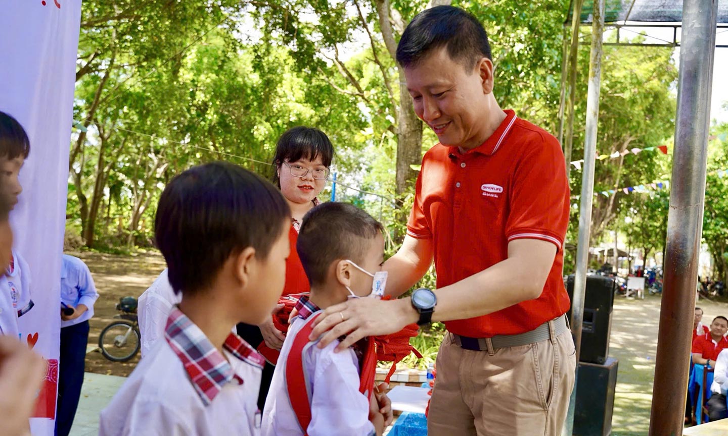 Ông Trần Đình Quân trao quà khuyến học cho các em học sinh Trường tiểu học B, thị trấn Cái Bè.