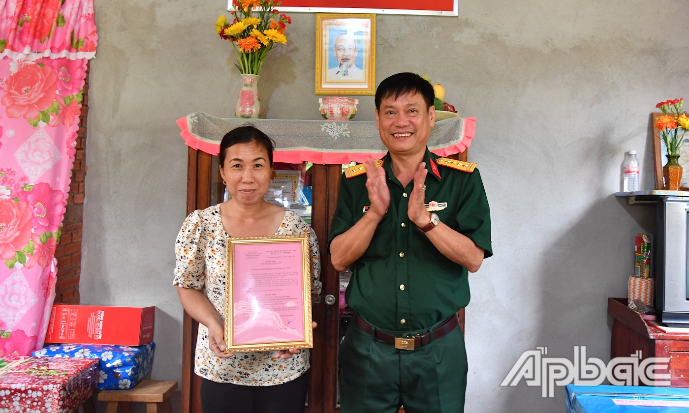 Đại tá Cao Văn Thảo, Phó Chính ủy Bộ CHQS tỉnh Tiền Giang trao Quyết định tặng “Nhà đại đoàn kết” cho bà Tăng Thị Mỹ Phượng.