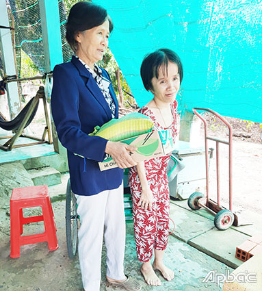 Bà Nguyễn Thị Mỹ Tiên, Chủ tịch Hội NNCĐDC huyện Tân Phú Đông, thăm hỏi, tặng quà  NNCĐDC Trần Thị Thúy Vân ở xã Phú Thạnh.