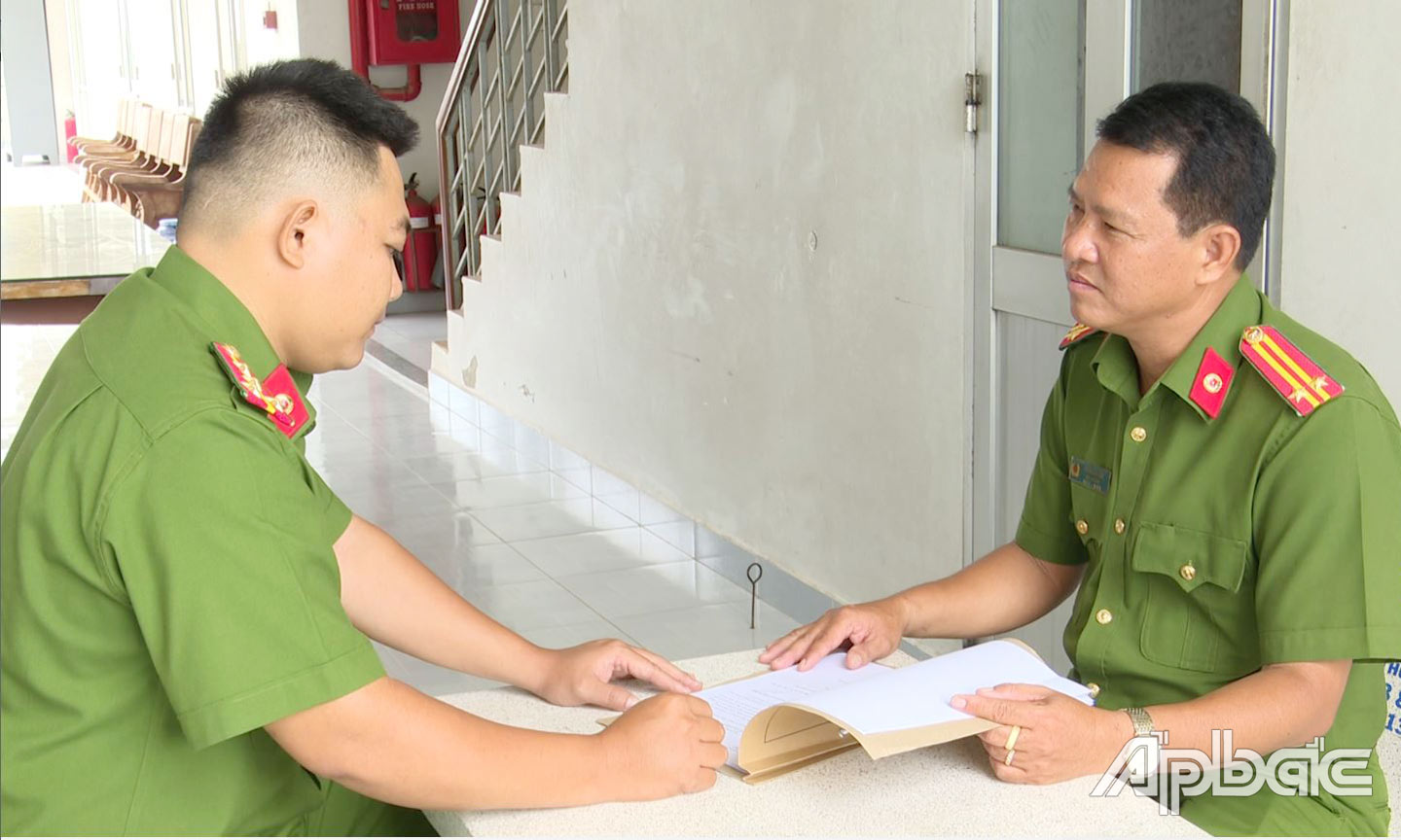 Trung tá Trần Văn Lâm (bên phải) trao đổi công việc với đồng đội. 	                                                                        ảnh: Trọng Tín