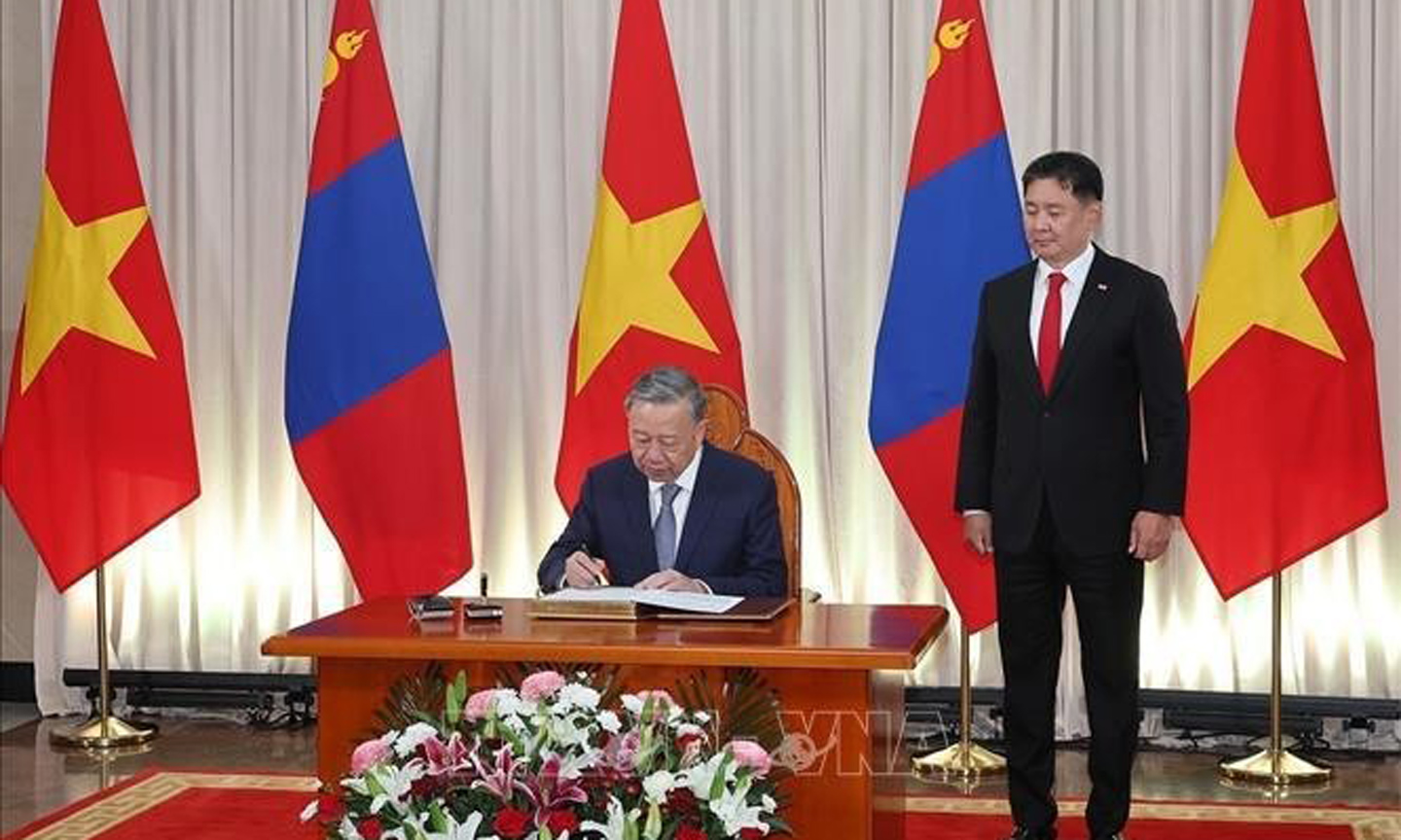 Party General Secretary and State President To Lam signs the honoured guest book in the presence of Mongolian President Ukhnaagiin Khurelsukh in Ulaanbaatar on September 30. (Photo: VNA).