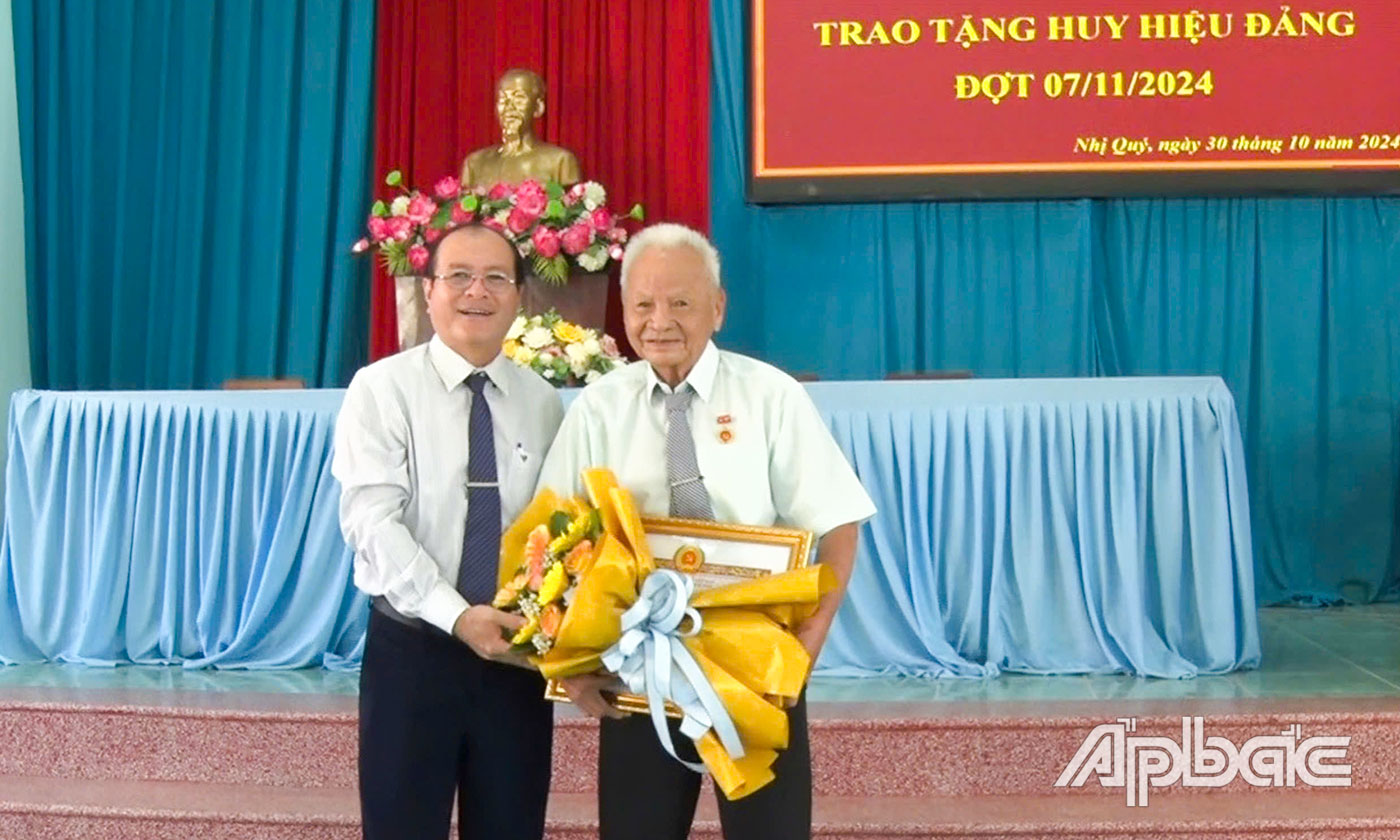 Đồng chí Trần Văn Thức, Phó Bí thư Thị ủy, Chủ tịch UBND TX. Cai Lậy trao Huy hiệu 60 năm tuổi Đảng cho đảng viên Đặng Văn Trương hiện đang sinh hoạt tại Đảng bộ xã Nhị Quý. Ảnh: PHƯƠNG TUYỀN