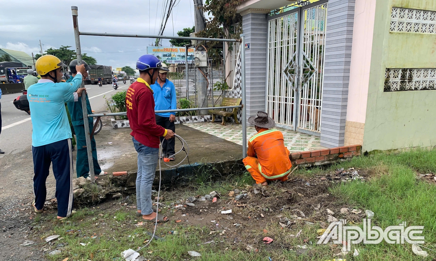 Lực lượng chức năng phối hợp xử lý các trường hợp lấn chiếm hành làng an toàn giao thông.