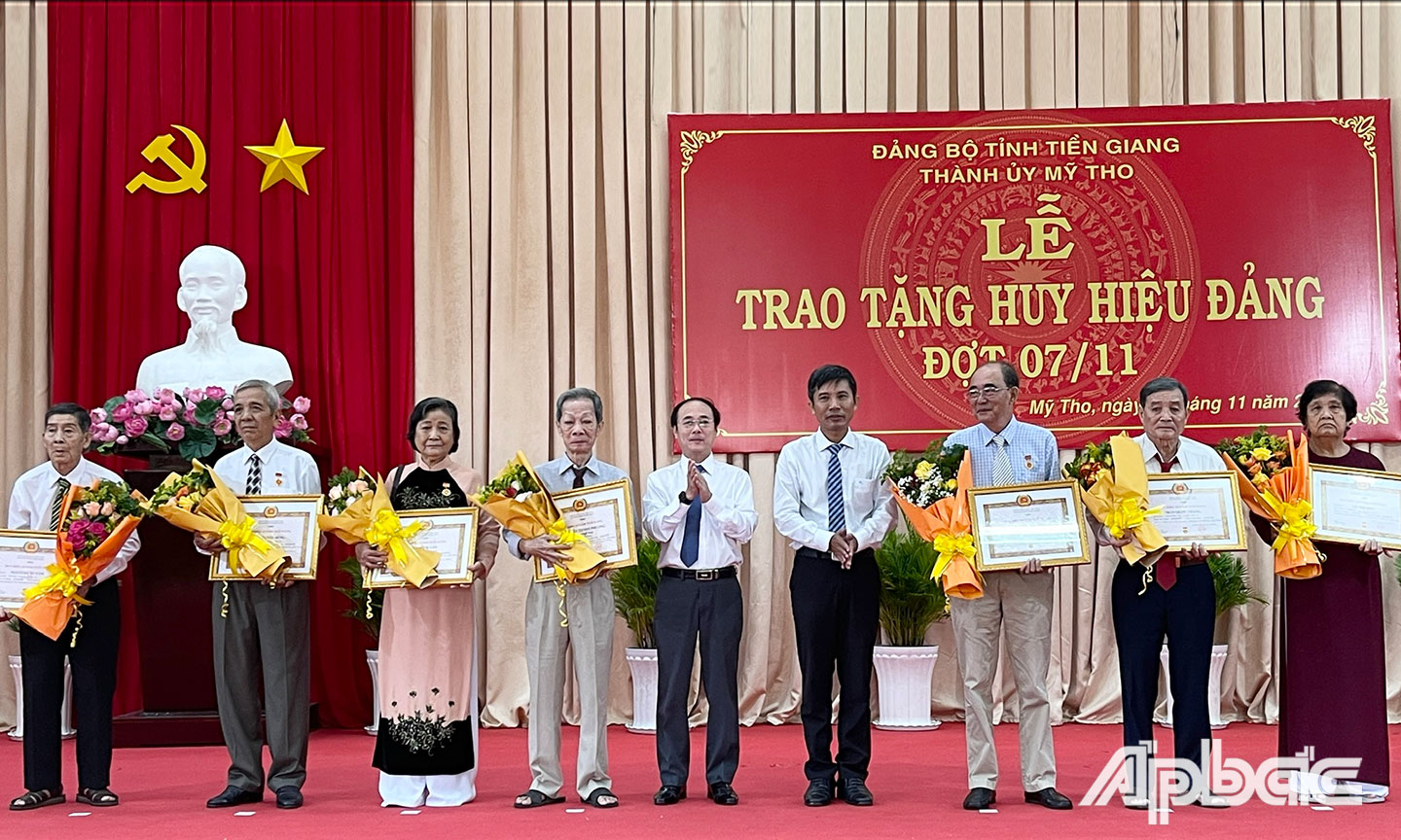 Đồng chí Trần Kim Trát - Ủy viên Ban Thường vụ Tỉnh ủy, Bí thư Thành ủy Mỹ Tho cùng lãnh đạo Thành ủy trao tặng huy hiệu Đảng cho các đảng viên.