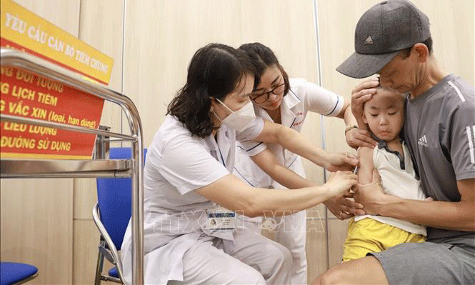 Nhân viên y tế quận Hoàn Kiếm (Hà Nội) tiêm vaccine cho trẻ tại điểm tiêm phường Phúc Tân. Ảnh: Vân Chi/TTXVN phát