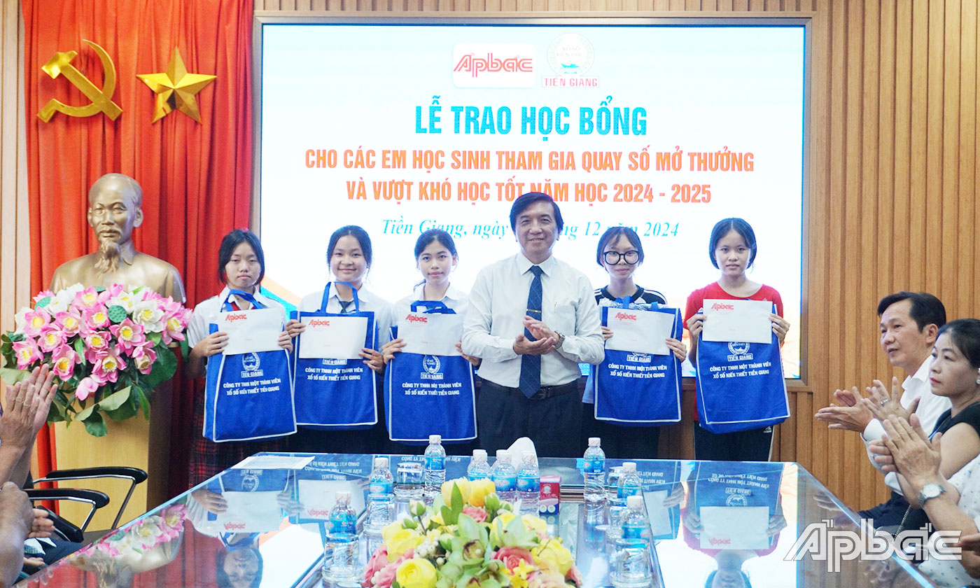 Chủ tịch Công ty TNHH MTV Xổ số kiến thiết Tiền Giang Nguyễn Minh Hiếu trao học bổng cho các em học sinh.