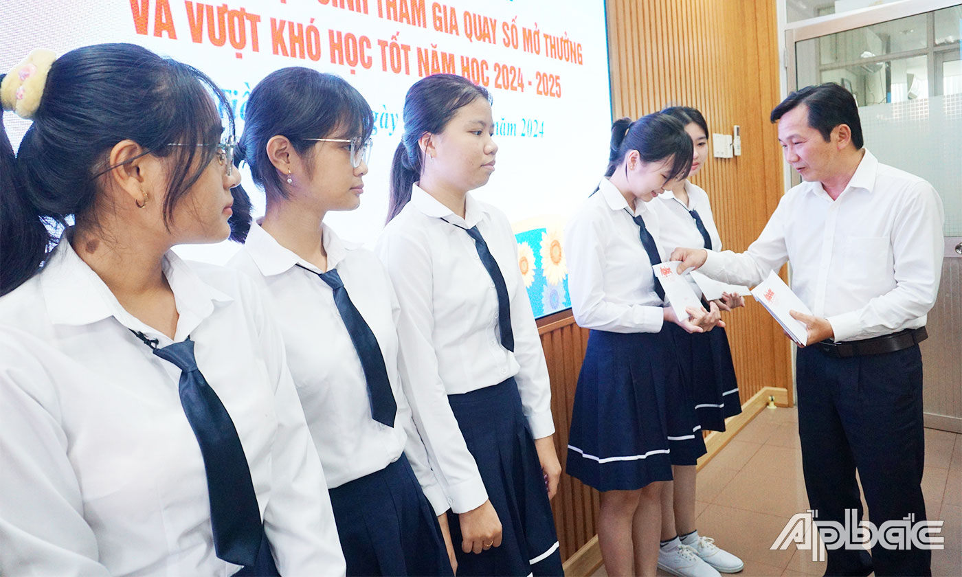 Phó Tổng Biên tập Báo Ấp Bắc Nguyễn Trọng Tấn trao học bổng cho các em học sinh. 