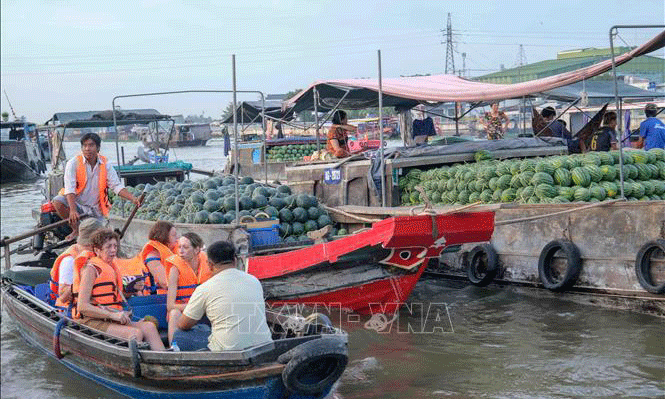 Du khách nước ngoài tham quan chợ nổi Cái Răng (Cần Thơ). Ảnh: Thanh Liêm/TTXVN