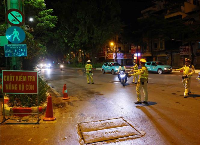 Cảnh sát giao thông (Công an thành phố Hà Nội) dừng xe, kiểm tra nồng độ cồn với các trường hợp tham gia giao thông. Ảnh: Phạm Kiên/TTXVN