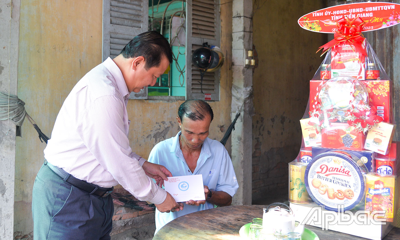 Đồng chí Phan Phùng Phú thăm, tặng quà ông Lê Văn Đực (thương binh 61%).