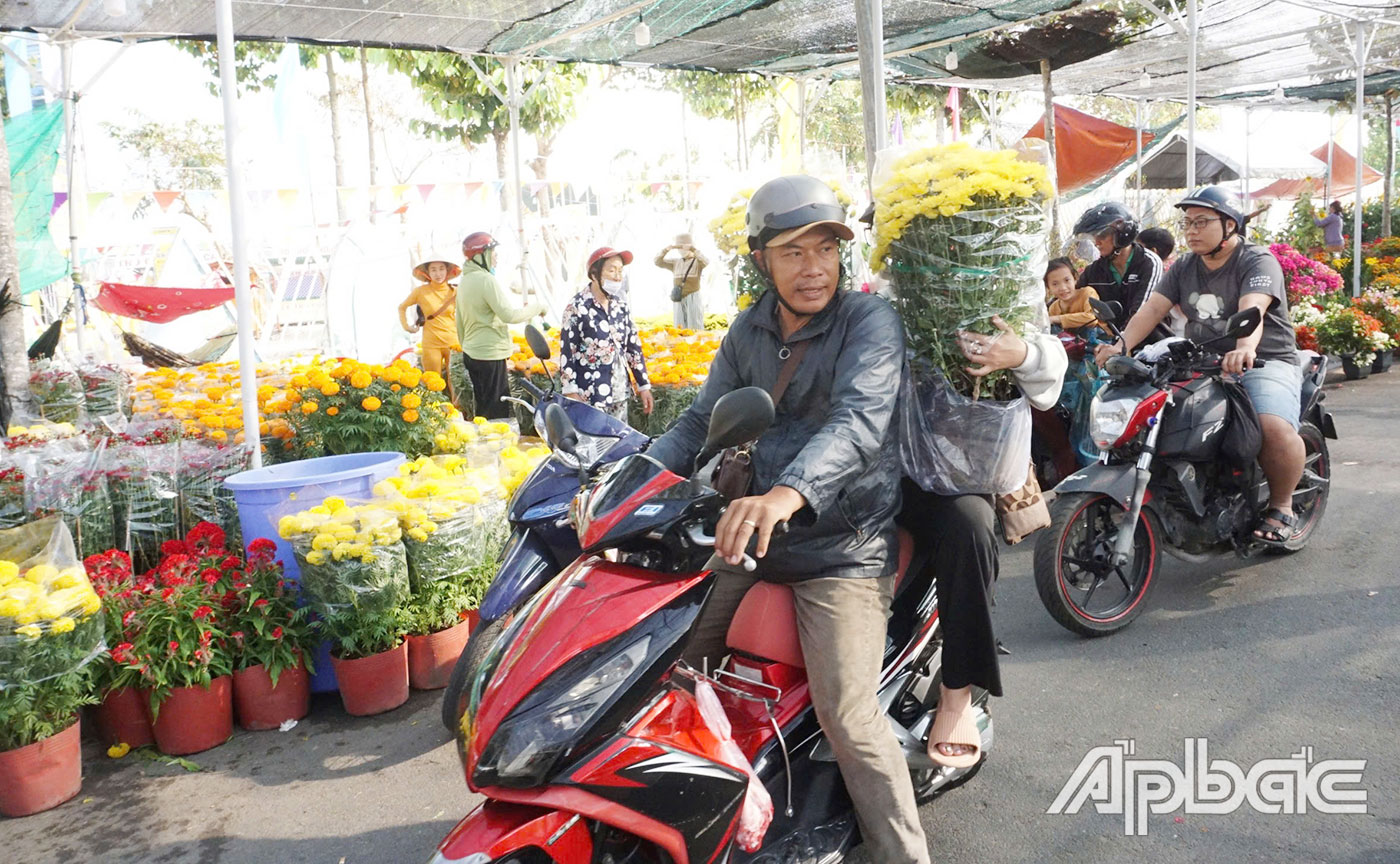 Người dân đến mua hoa tết tại Chợ hoa Xuân TP. Mỹ Tho vào sáng 28 tết.