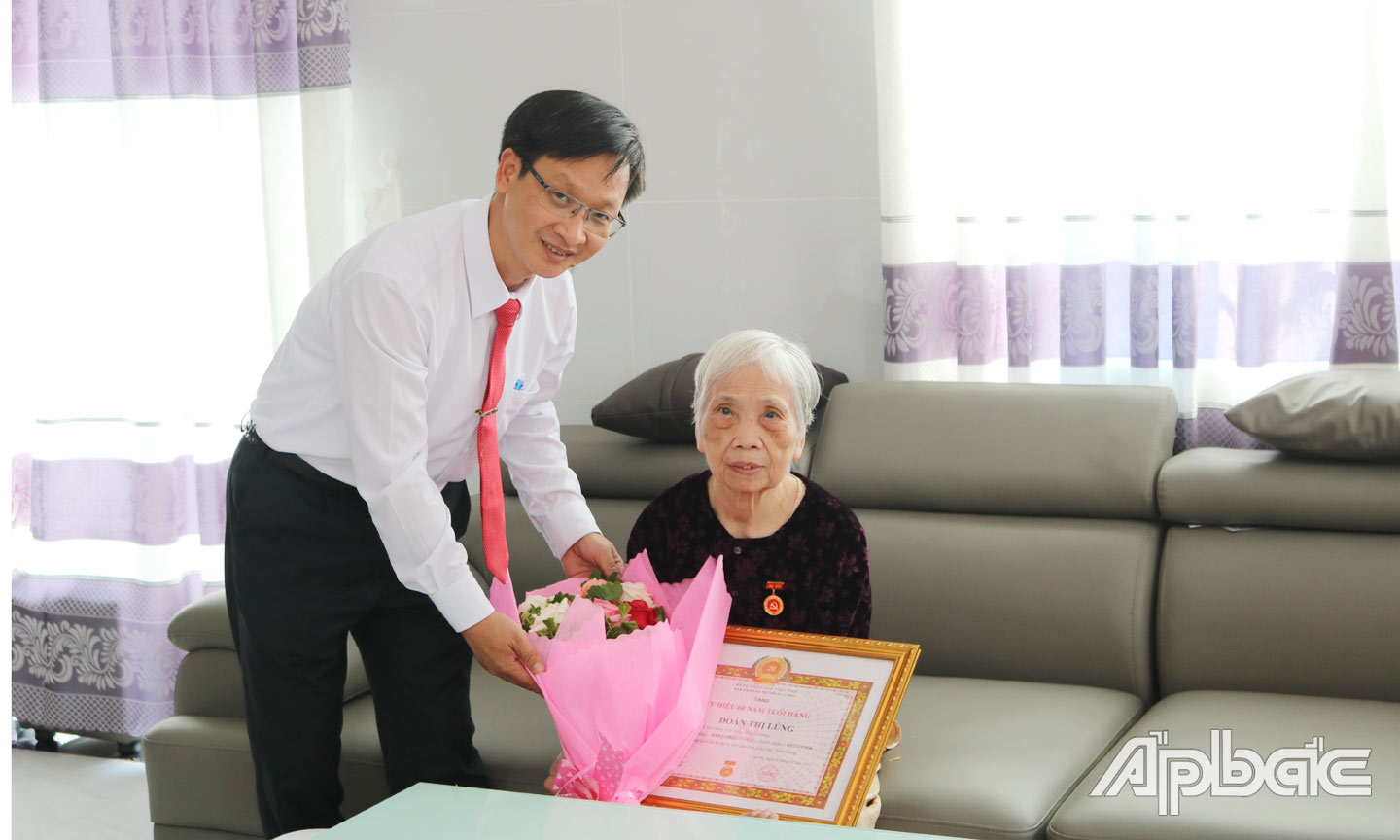Ông Huỳnh Vũ Phương trao Huy hiệu Đảng cho đảng viên cao niên.