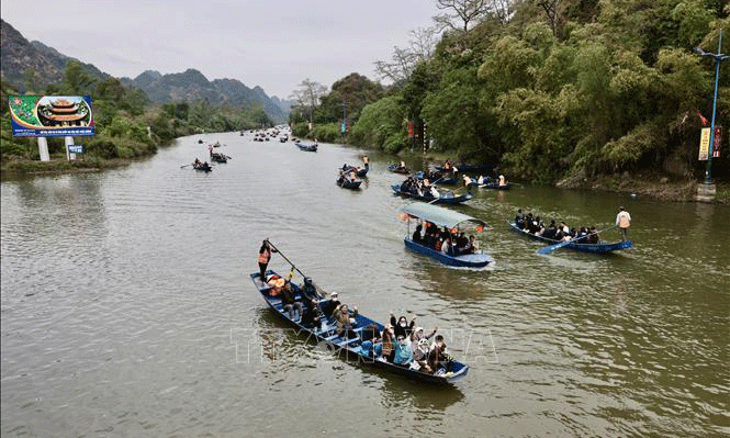 Suối Yến (Quần thể di tích Quốc gia đặc biệt Hương Sơn - chùa Hương, huyện Mỹ Đức, TP Hà Nội) tấp nập dòng thuyền chở khách trẩy hội vui Xuân. Ảnh: Trần Việt/TTXVN