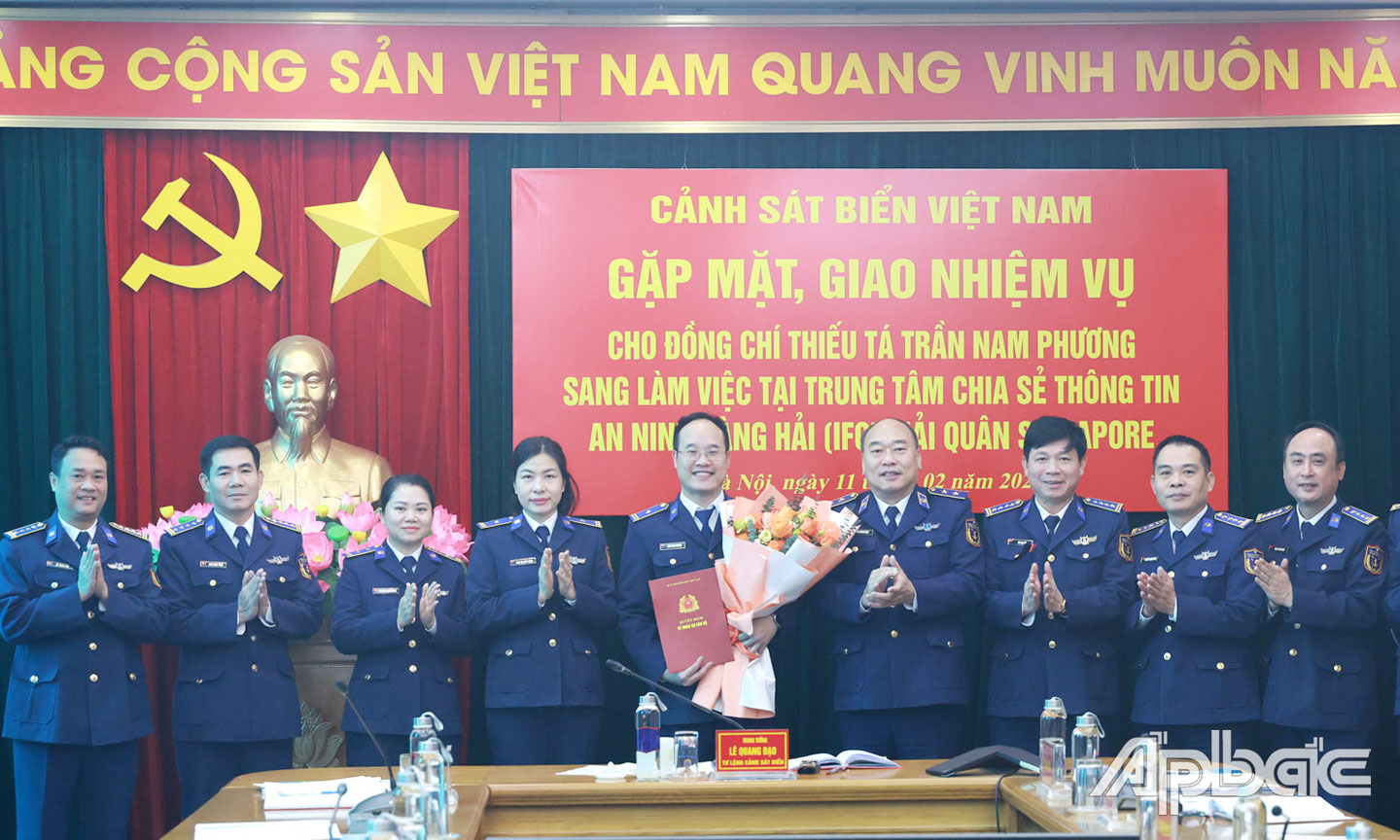 Thủ trưởng Bộ Tư lệnh và đại diện các cơ quan chức năng tặng hoa, chụp ảnh lưu niệm với Thiếu tá Trần Nam Phương.