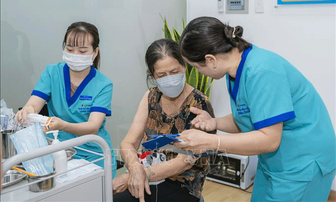 Người dân tiêm vaccine phòng cúm tại Trung tâm Tiêm chủng FPT Long Châu. Ảnh: TTXVN phát