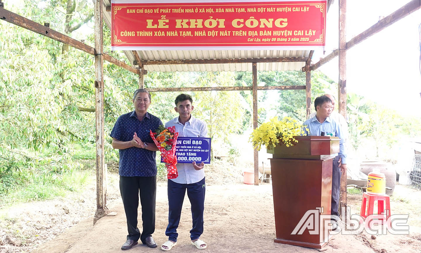: Ông Nguyễn Văn Bằng, Tỉnh ủy viên, Bí thư Huyện ủy, Trưởng Ban chỉ đạo huyện trao bảng tượng trưng kinh phí xây dựng nhà ở cho ông Lê Văn Tâm