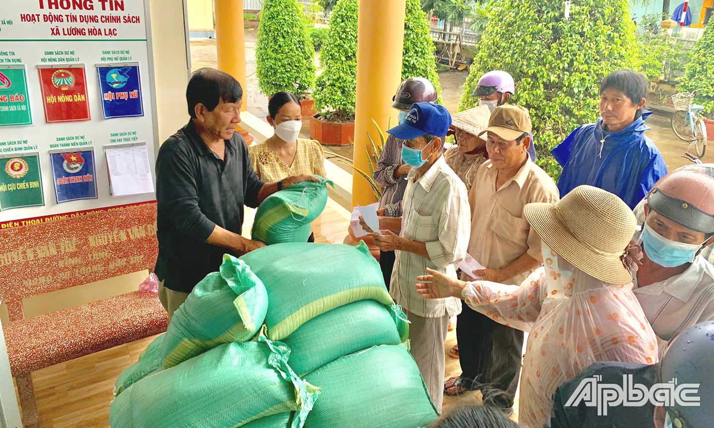 Ông Kim Hùng, Chủ tịch Hội NNCĐDC xã Lương Hòa Lạc, phát gạo cho nạn nhân.