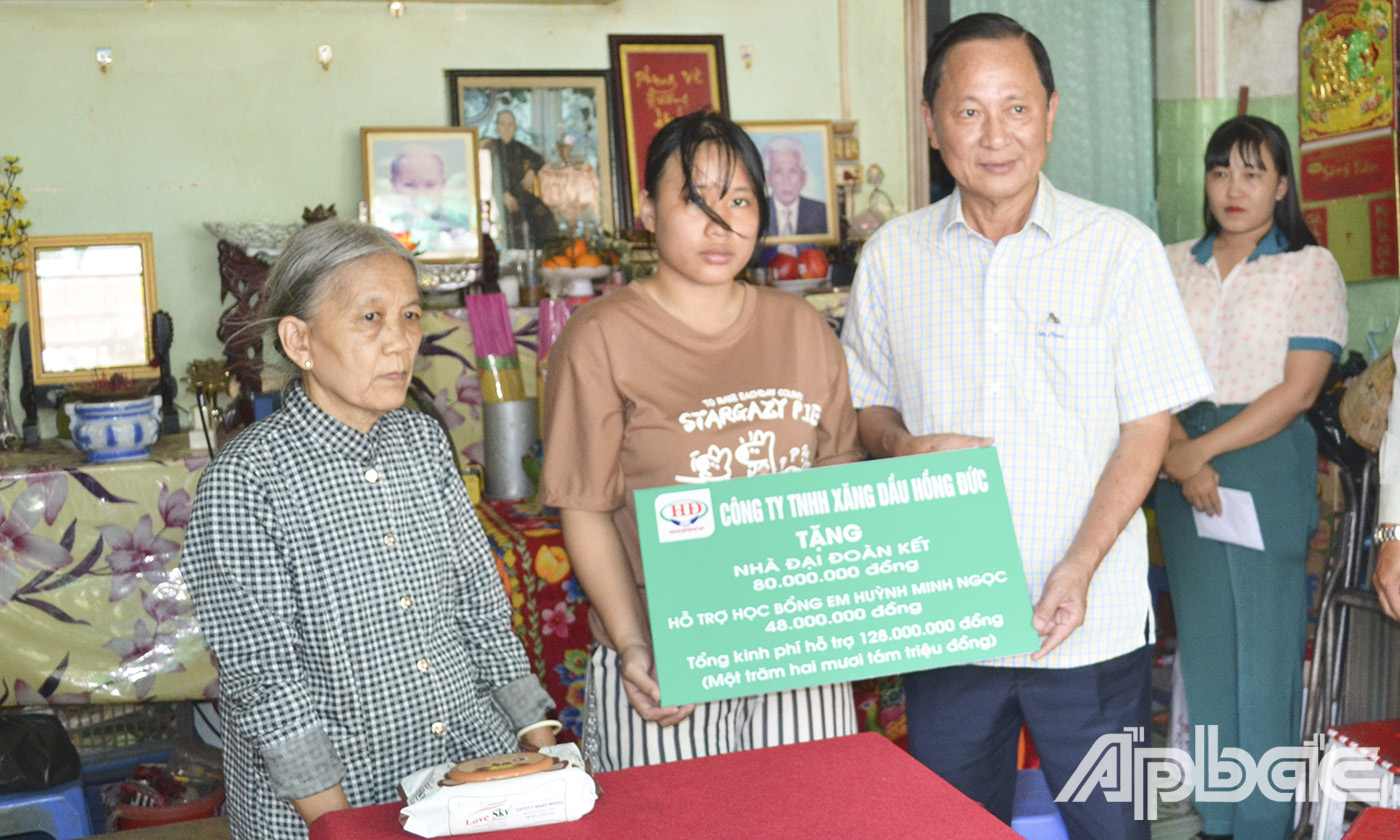Ông Đinh Văn Hữu, đại diện lãnh đạo Công ty TNHH Xăng dầu Hồng Đức tặng 128 triệu đồng tổng kinh phí hỗ trợ cho gia đình em Nguyễn Huỳnh Minh Ngọc.