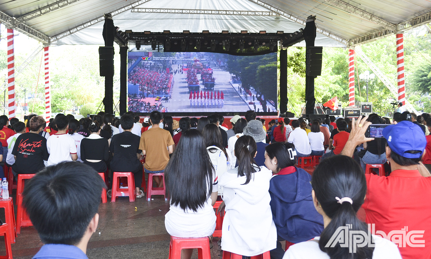Người dân theo dõi buổi Lễ kỷ niệm 50 năm Ngày Giải phóng miền Nam, thống nhất đất nước (30-4-1975 - 30-4-2025) qua màn hình LED cỡ lớn tại Công viên Tết Mậu Thân, TP. Mỹ Tho.