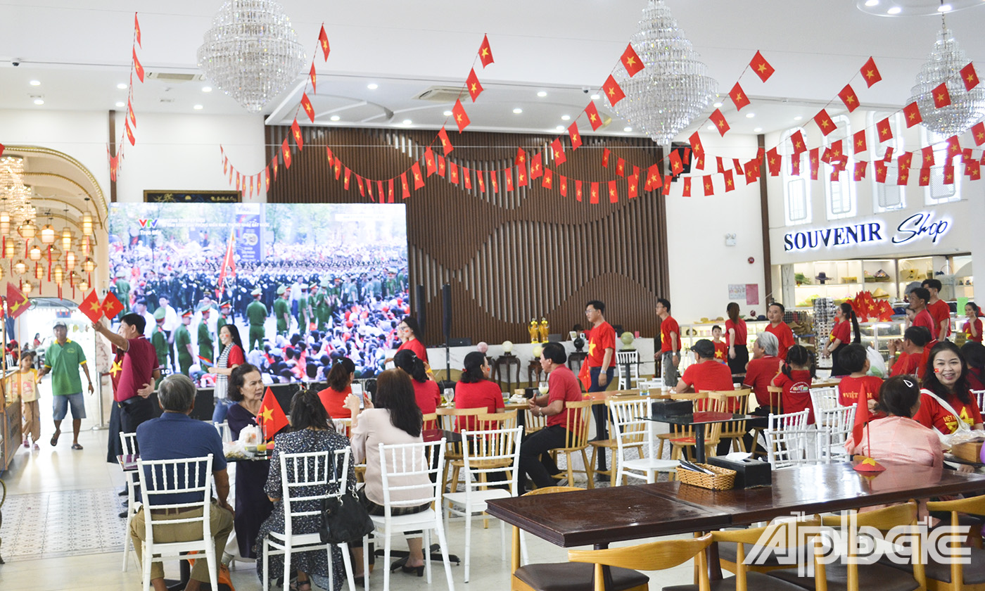 Người dân và du khách theo dõi buổi Lễ kỷ niệm 50 năm Ngày Giải phóng miền Nam, thống nhất đất nước (30-4-1975 - 30-4-2025) qua màn hình LED cỡ lớn tại Cảnh du thuyền Mỹ Tho.