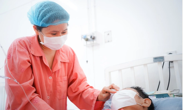 Vợ bệnh nhân ghép thận vào thăm chồng sau ca mổ. Ảnh: Bệnh viện cung cấp