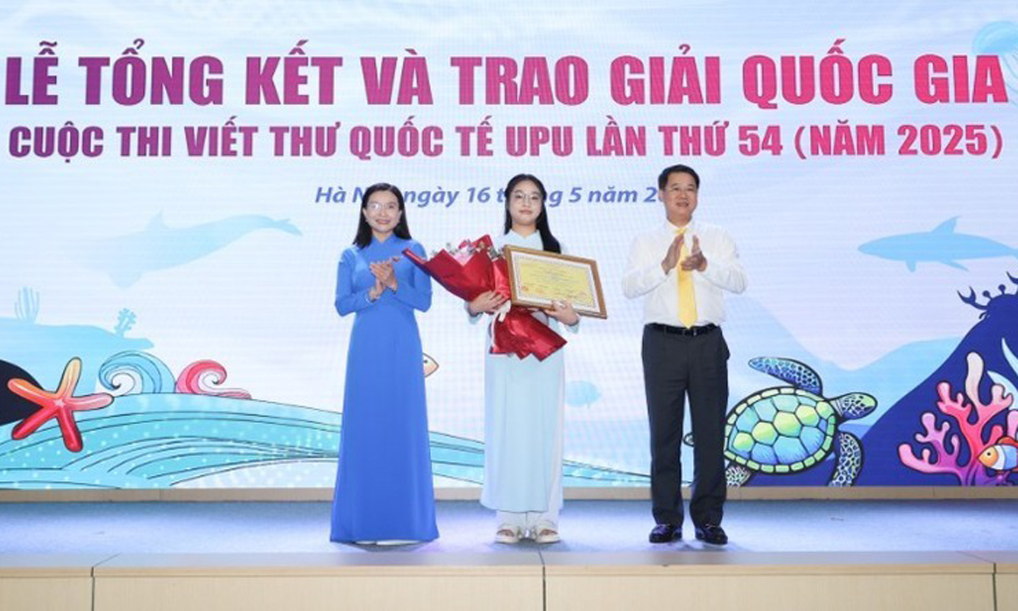 Pham Doan Minh Khue (C) receives first prize of 54th UPU letter-writing contest at the awards ceremony.