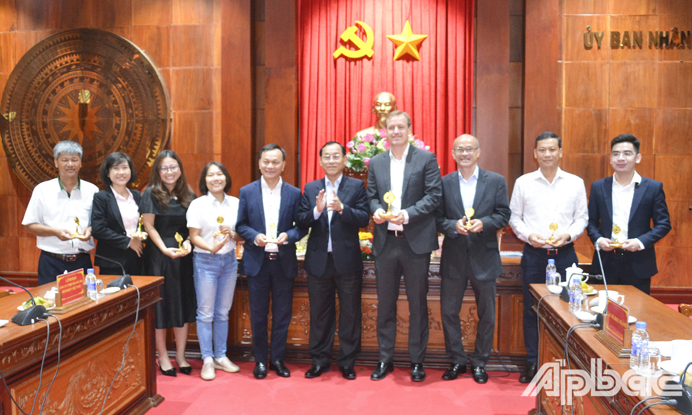 Đồng chí Nguyễn Văn Vĩnh, Chủ tịch UBND tỉnh tặng biểu trưng lưu niệm cho các đại diện Công ty TNHH Nhà máy bia HEINEKEN Việt Nam.