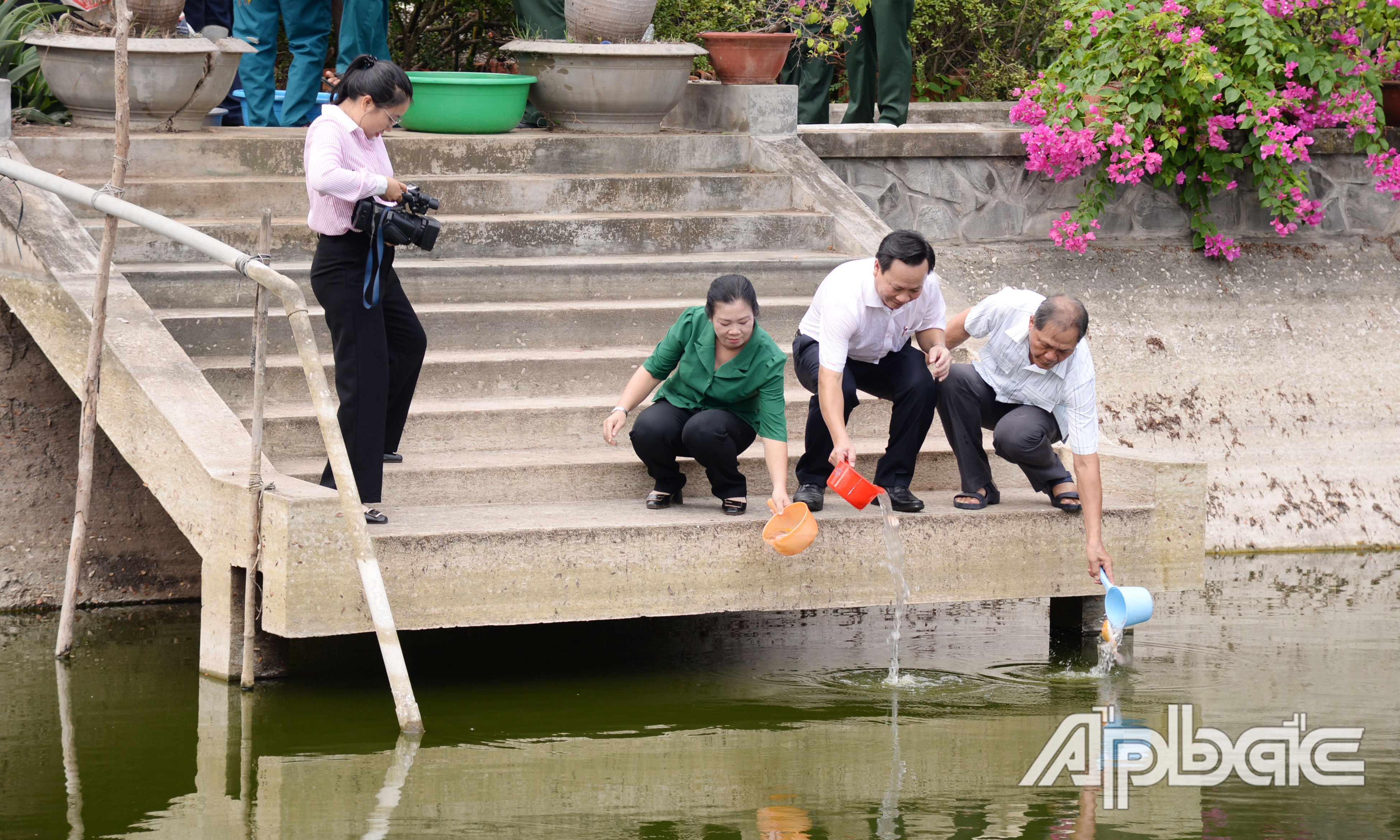 Các đại biểu thực hiện thả cá tại Ao Đền thờ Võ Tánh.