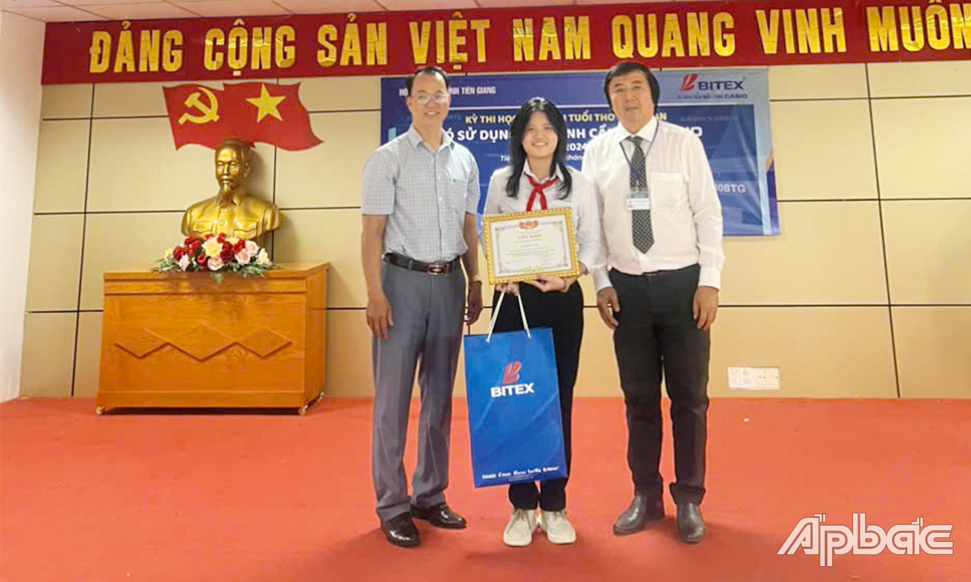 Ban Tổ chức trao giải Nhất lớp 9 cho em Trần Yến Nhi học sinh lớp 9, trường THCS An Hữu, huyện Cái Bè