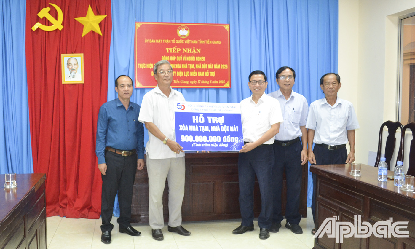Đại diện đơn vị tài trợ ông Trần Quang Tâm (bên phải ảnh), Phó Giám đốc Công ty Điện lực Tiền Giang trao Bảng tượng trưng 900 triệu đồng cho Ủy Ban MTTQ Việt Nam tỉnh Tiền Giang.