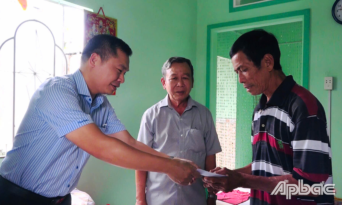 , Bí thư Đảng ủy, Chủ tịch HĐND xã Trần Quốc Bình ân cần thăm hỏi sức khỏe và trao tặng quà cho các gia đình chính sách