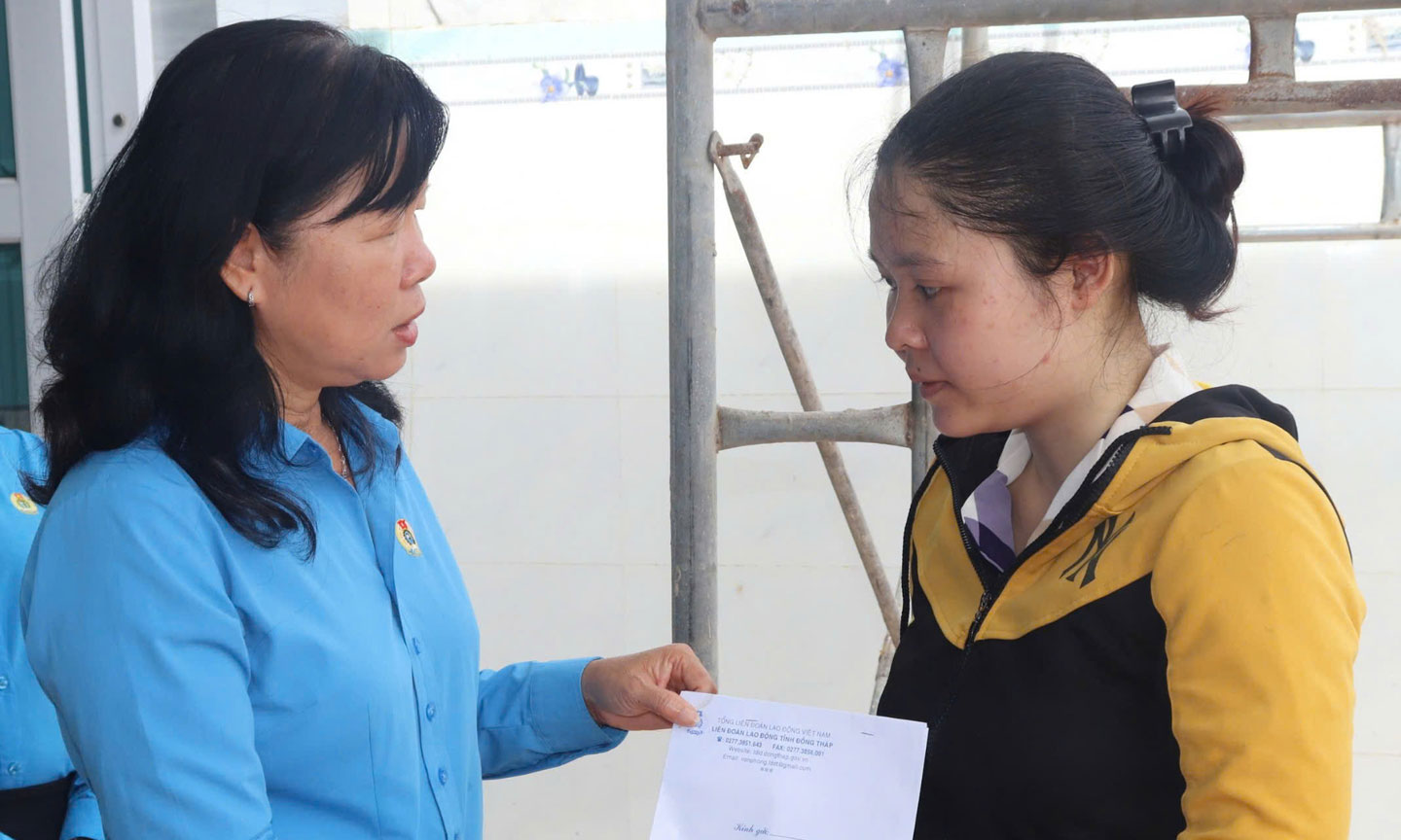 Bà Huỳnh Thị Tuyết Vui - Chủ tịch LĐLĐ tỉnh trao hỗ trợ cho đoàn viên Lê Thị Trúc Ly,