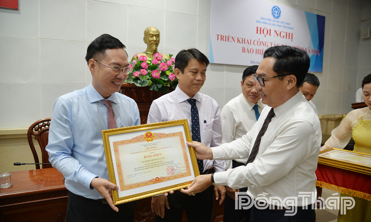 Anh Nguyễn Duy Khương (bìa trái) nhận Bằng khen của Thủ tướng Chính phủ vì có thành tích xuất sắc trong công tác tại Hội nghị triển khai công tác bảo hiểm xã hội, bảo hiểm y tế năm 2025.