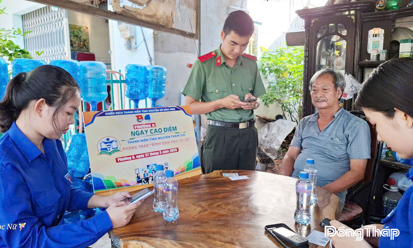 Đoàn viên - thanh niên tình nguyện hướng dẫn người dân tích hợp thẻ bảo hiểm y tế lên VNeID, truy cập dịch vụ công trực tuyến.